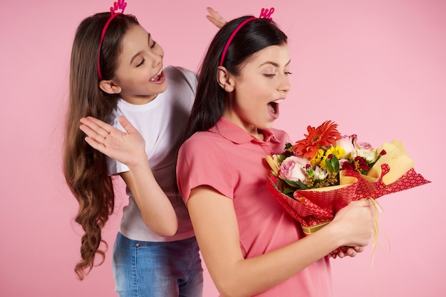 La piccola figlia piacevole dà i fiori a bello