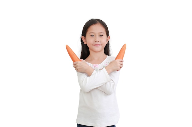 La piccola ragazza asiatica che tiene la carota e il gesto attraversano un braccio