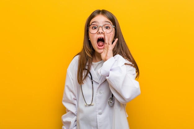 La piccola ragazza caucasica che porta un gridare del costume di medico ha eccitato alla parte anteriore.