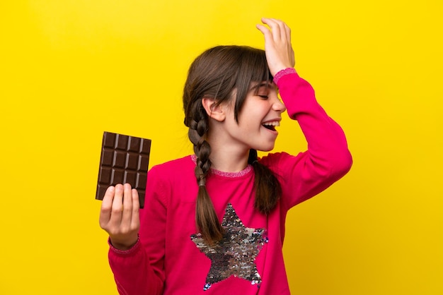 La piccola ragazza caucasica con cioccolato isolato su sfondo giallo ha realizzato qualcosa e intendeva la soluzione
