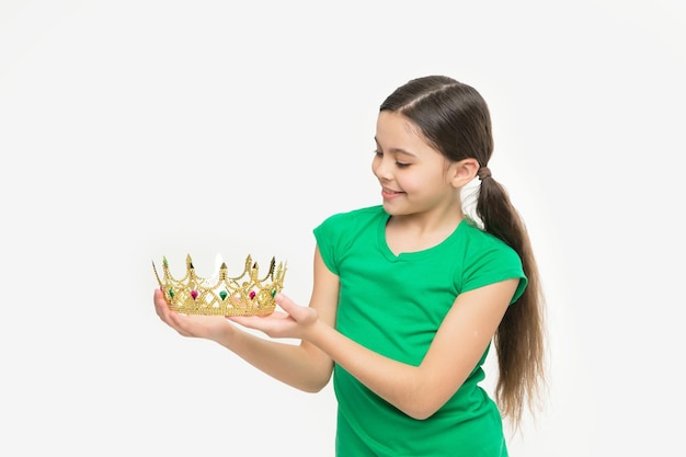 La piccola ragazza che sta per provare una corona mi sta bene la mia migliore ricompensa di sempre ispirazione e motivazione raggiungere il futuro successo regina della sua vita piccola principessa tenere una corona di lusso