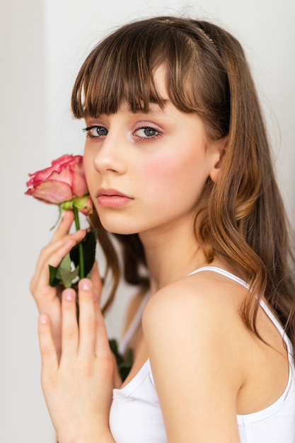 La piccola ragazza graziosa in rosa tiene il mazzo delle rose. Chiudere i fiori e il viso, piccola ballerina con un bouquet, graziosa bambina con rosa rosa