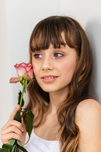 La piccola ragazza graziosa in rosa tiene il mazzo delle rose. Chiudere i fiori e il viso, piccola ballerina con un bouquet