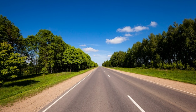 La piccola strada asfaltata rurale fotografata nell'estate dell'anno. Bielorussia