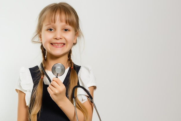 la piccola studentessa studia medicina con il fonendoscopio, isolata on white