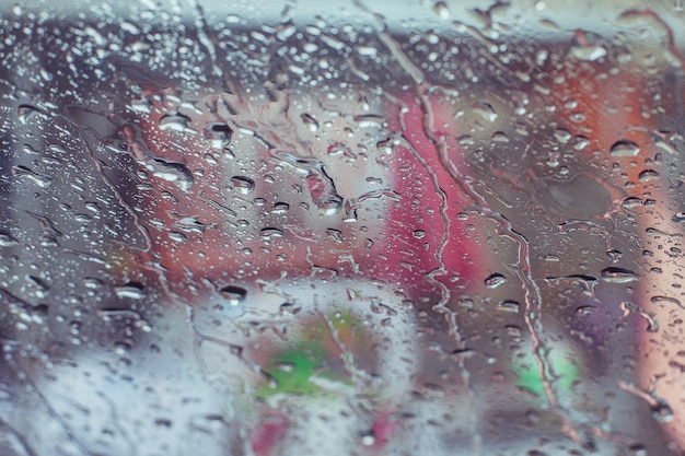 La pioggia cade l&#39;acqua sul fondo di superficie della finestra di automobile, vista dall&#39;auto che ora piove fondo