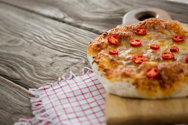 La pizza è servita su un tagliere con un panno su una tavola di legno