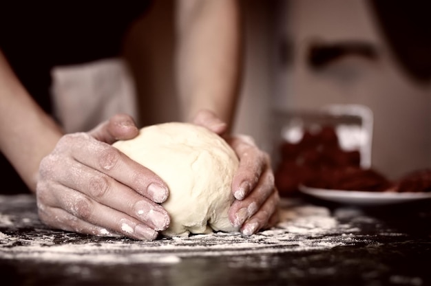 La pizza prepara la farcitura a mano dell'impasto