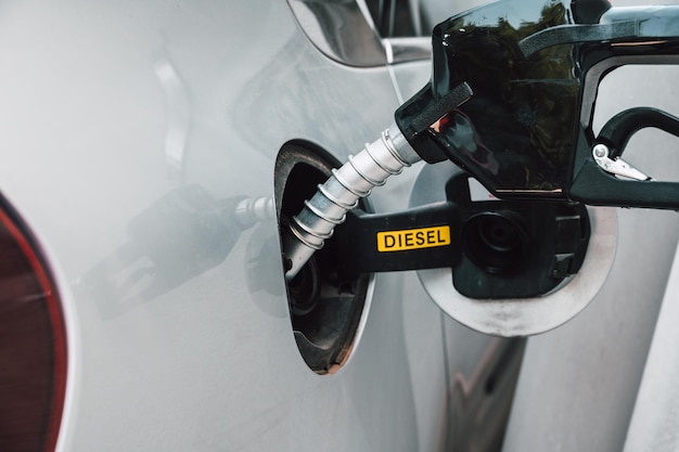 La pompa del carburante riempie un serbatoio di un'auto in una stazione