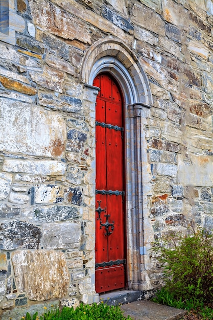 La porta rossa della chiesa medievale in pietra