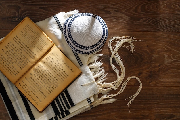 La preghiera tradizionale ebraica fornisce Talite kippah torah su un tavolo di legno Shabbatta Bar Mitzvah Yom kippur concept