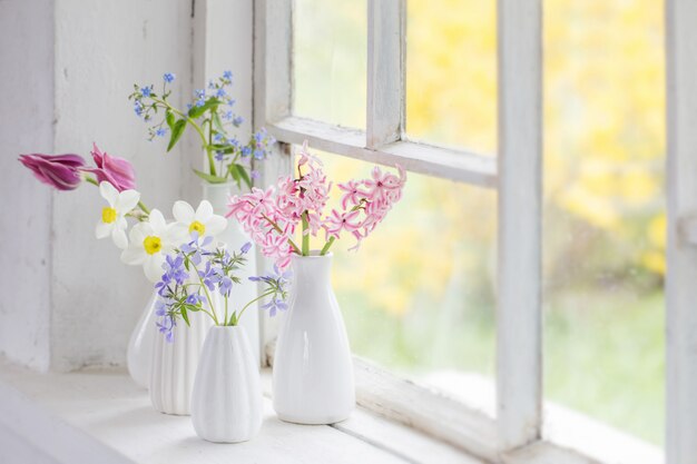 La primavera fiorisce in vaso bianco sul vecchio davanzale