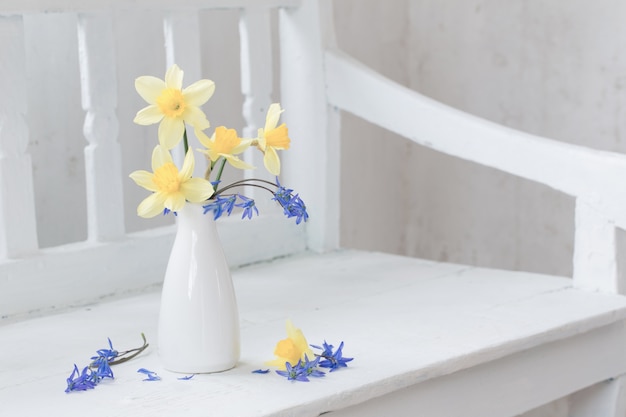 La primavera fiorisce in vaso sul banco di legno bianco