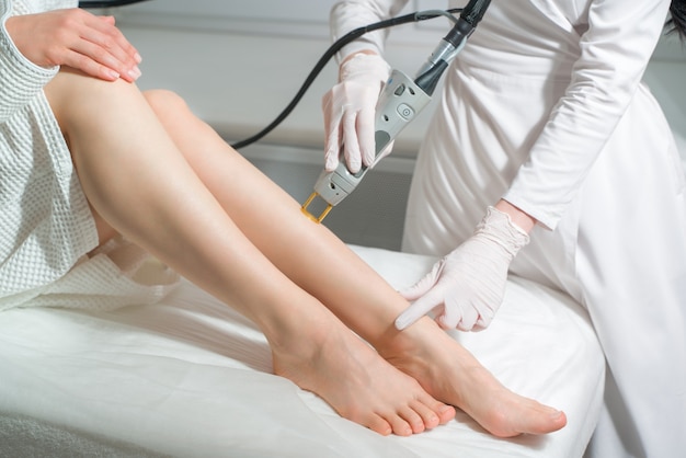 La procedura per la rimozione dei peli sul corpo di una donna in una depilazione laser clinica di cosmetologia