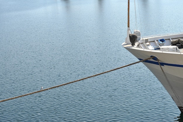 La prua di uno yacht ormeggiato con una cima di ormeggio nel porto.