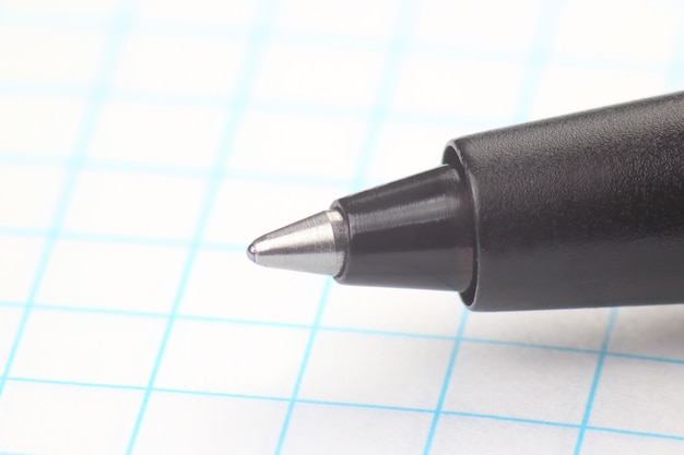 La punta della penna per scrivere sullo sfondo del foglio bianco nella scatola
