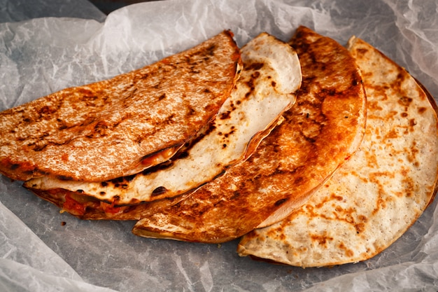 La quesadilla messicana fatta in casa è impilata su una pergamena.