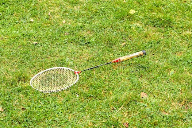 La racchetta da badminton sdraiata sull'erba verde