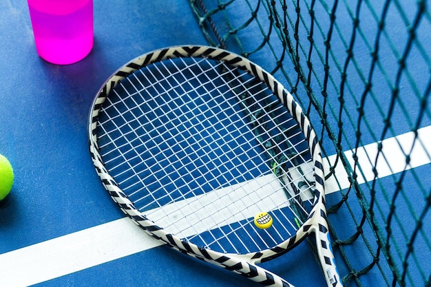La racchetta da tennis con emoji sorridente si trova sul campo da tennis Vista dall'alto Foto orizzontale
