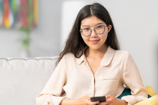 La ragazza abbastanza attraente con gli occhiali di carnagione perfetta sorride asiatiche di bellezza