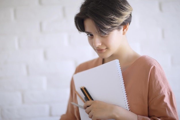 la ragazza adulta disegna su matite di carta / ritratto di una bella giovane studentessa, istruzione scolastica d'arte, concetto di educazione artistica