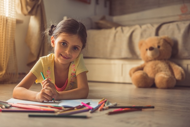 La ragazza affascinante sta disegnando e sorridendo