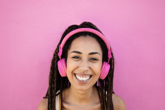 La ragazza africana boema ascolta la musica della playlist con le cuffie - Focus on face