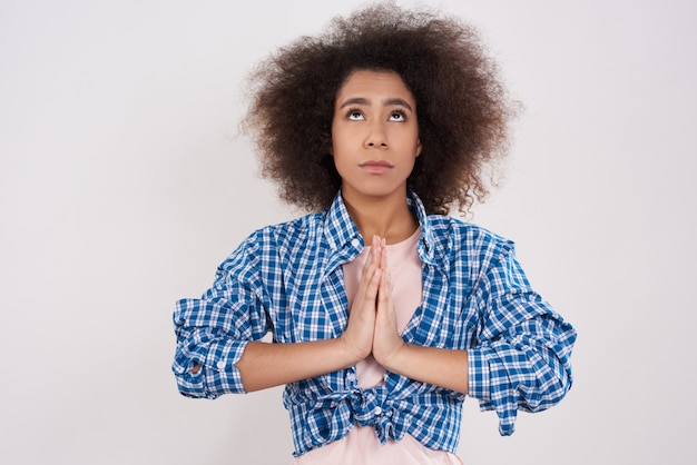 La ragazza africana sta pregando isolata