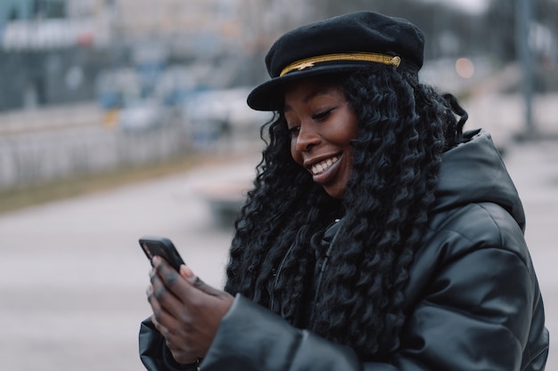 La ragazza afro usa il telefono all'aperto persone che usano la tecnologia