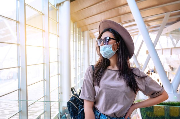 La ragazza alla finestra dell'aeroporto aspetta un volo