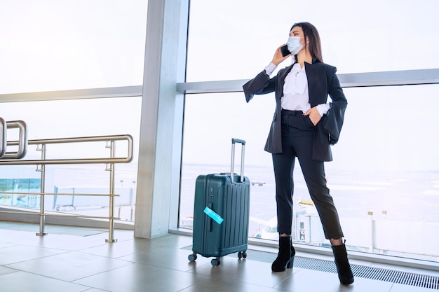 La ragazza alla finestra dell'aeroporto aspetta un volo