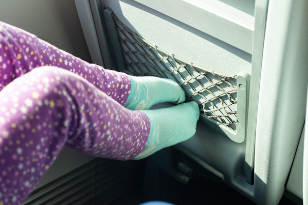 La ragazza appoggia i piedi sul sedile di un treno o di un autobus