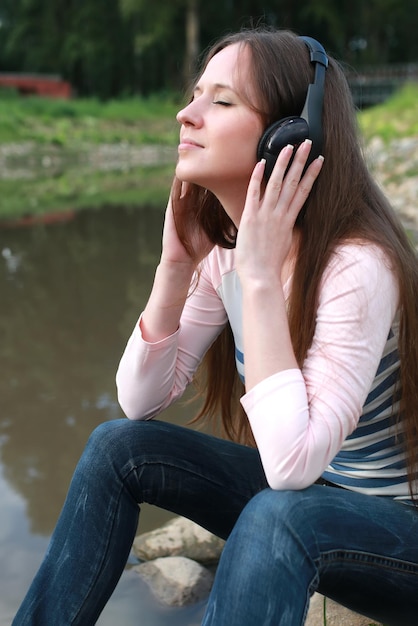 La ragazza ascolta musica in cuffia all'aperto