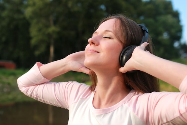 La ragazza ascolta musica in cuffia all'aperto