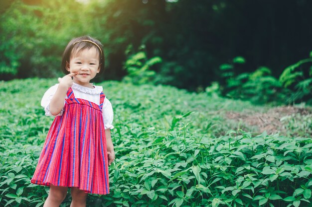 La ragazza asiatica adorabile gode del giardino a casa