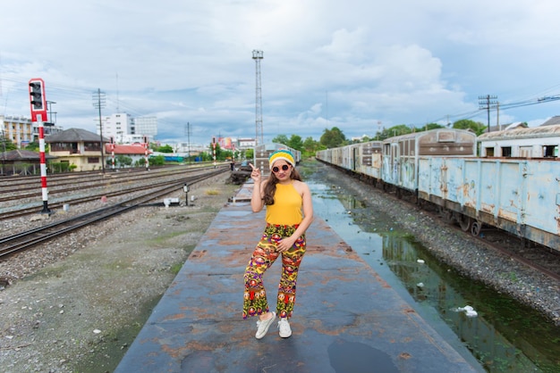 La ragazza asiatica dei pantaloni a vita bassa posa per scattare una fotoRitratto di moda bella donna alla ferroviastile di vita della moderna ragazza tailandese adolescenzialeTessuti coloratipersone thailandesi