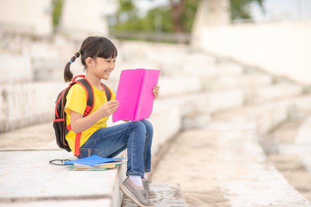 La ragazza asiatica ha letto un libro, concetto di abilità di apprendimento