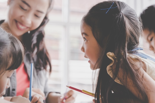 La ragazza asiatica sta assorbendo l&#39;aula di arte di asilo