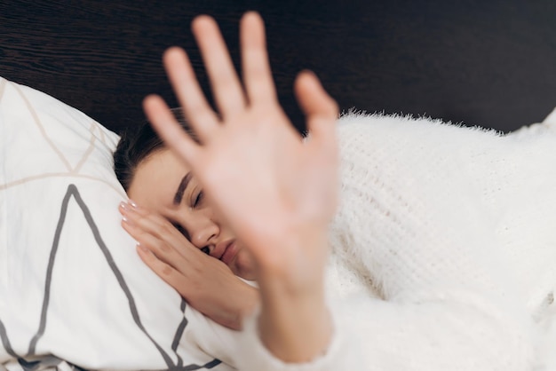 La ragazza assonnata scontenta a letto non vuole alzarsi presto la mattina