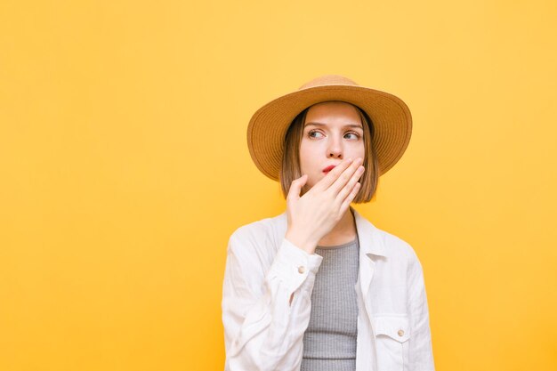 La ragazza attraente si coprì ciecamente la bocca e distoglie lo sguardo verso lo spazio vuoto