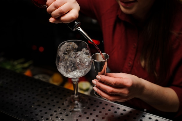 La ragazza barista prepara un cocktail in discoteca.