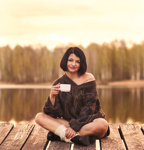 La ragazza beve le emozioni del caffè all'aperto