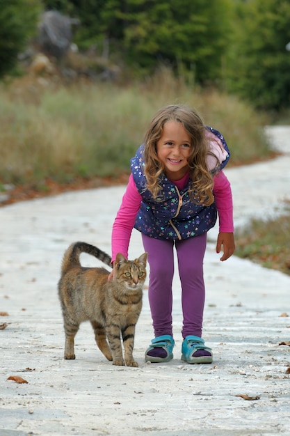 La ragazza bionda di 4 anni accarezza un gattino