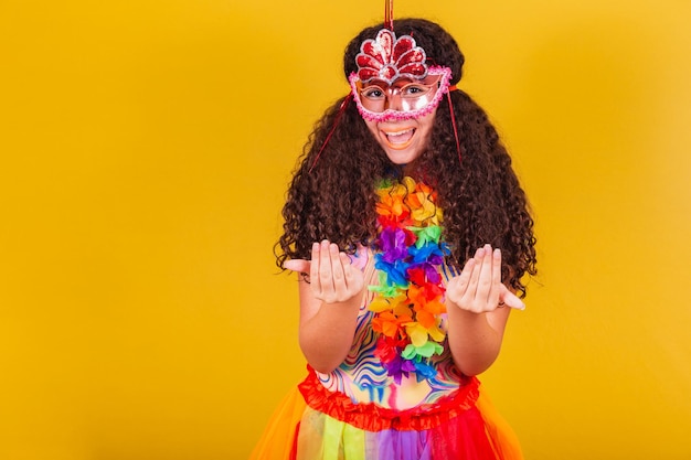 La ragazza brasiliana caucasica vestita per il carnevale che chiama con le mani viene qui