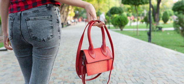 La ragazza cammina nel parco con una borsetta
