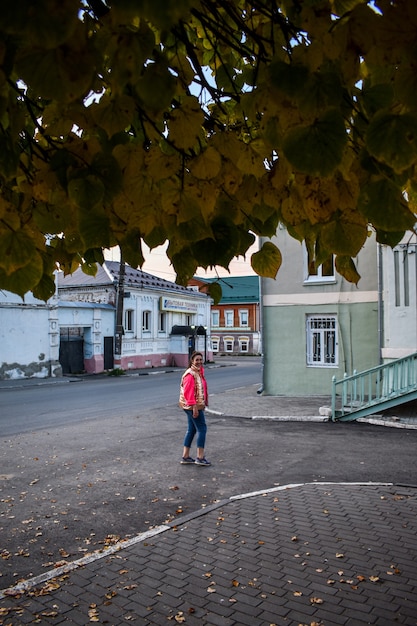 La ragazza cammina per la città in autunno