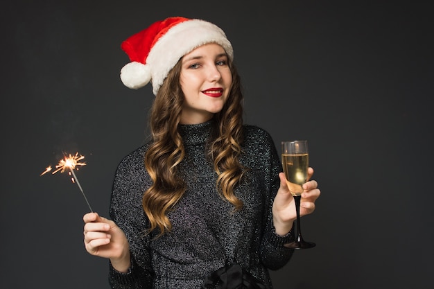 La ragazza carina con il cappello di babbo natale festeggia il natale e il capodanno