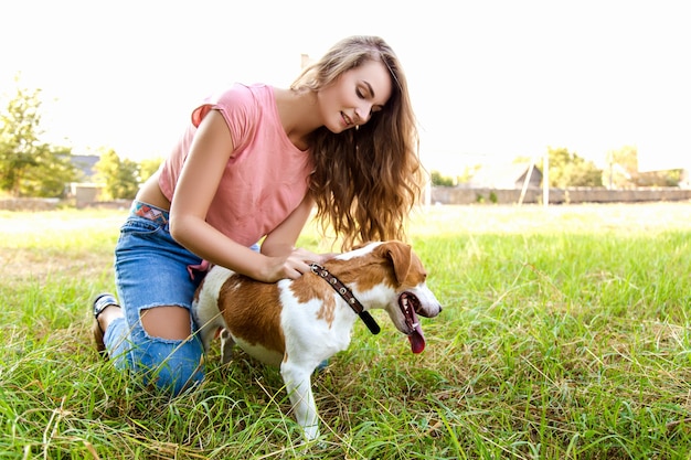 La ragazza carina sta giocando con il suo cane nel parco