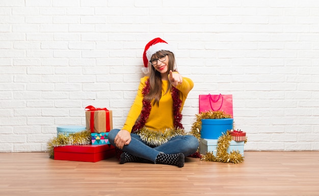 La ragazza che celebra le vacanze di Natale punta il dito verso di te