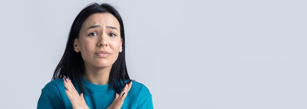 La ragazza che disapprova senza il segno delle mani incrociate fa un gesto di negazione Ritratto di bella donna su sfondo grigio